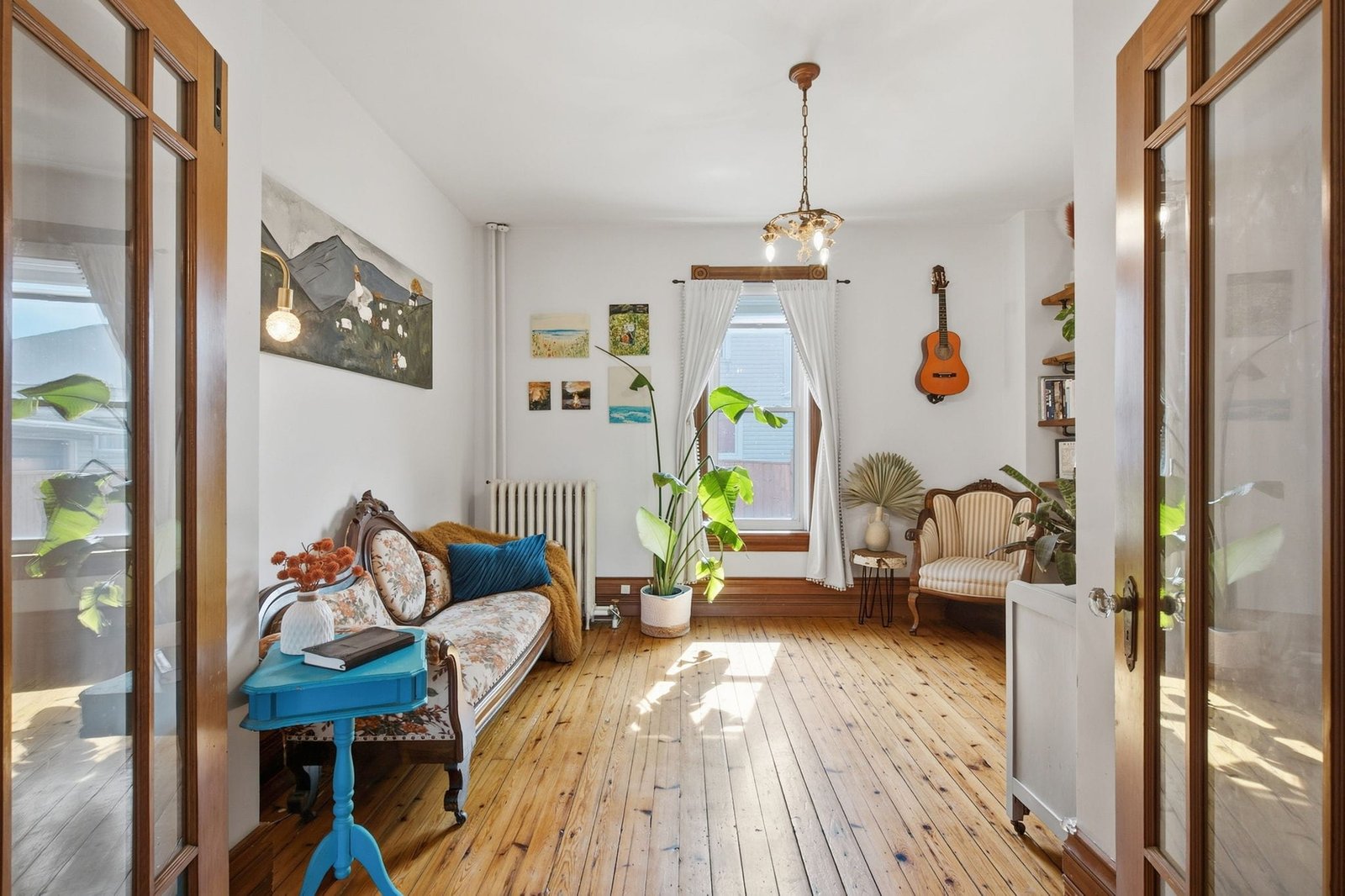 Main floor sitting room with wide plank floors and glass doors
