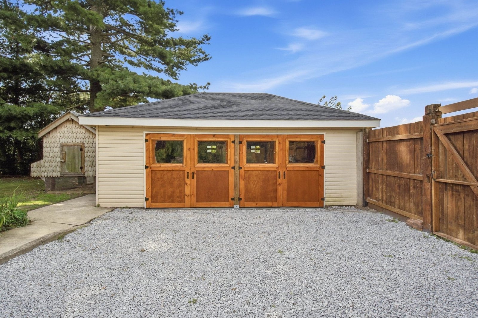 Detached two car garage with custom carriage doors and gravel driveway