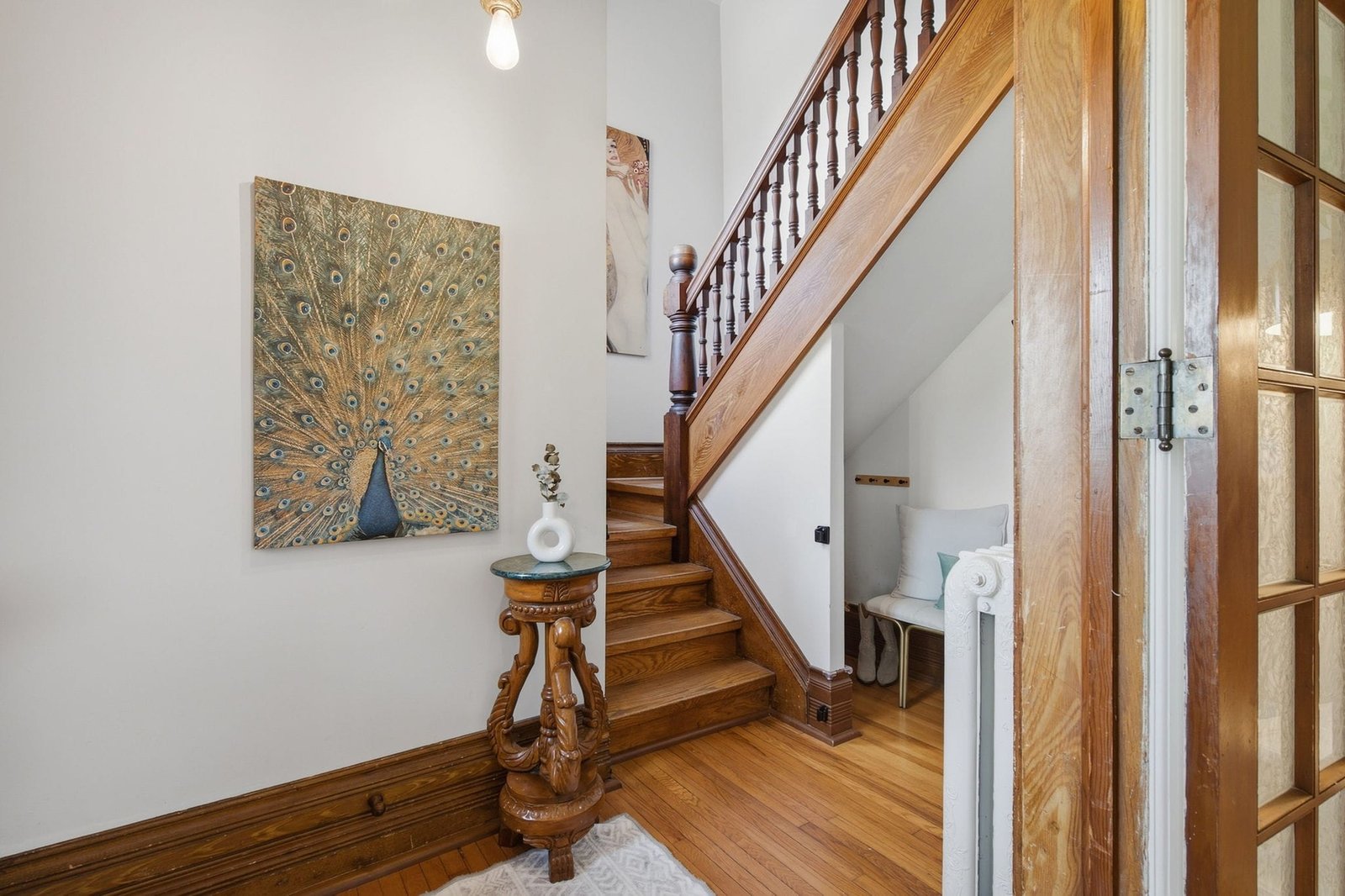 Original wood staircase and newel post in the front hall