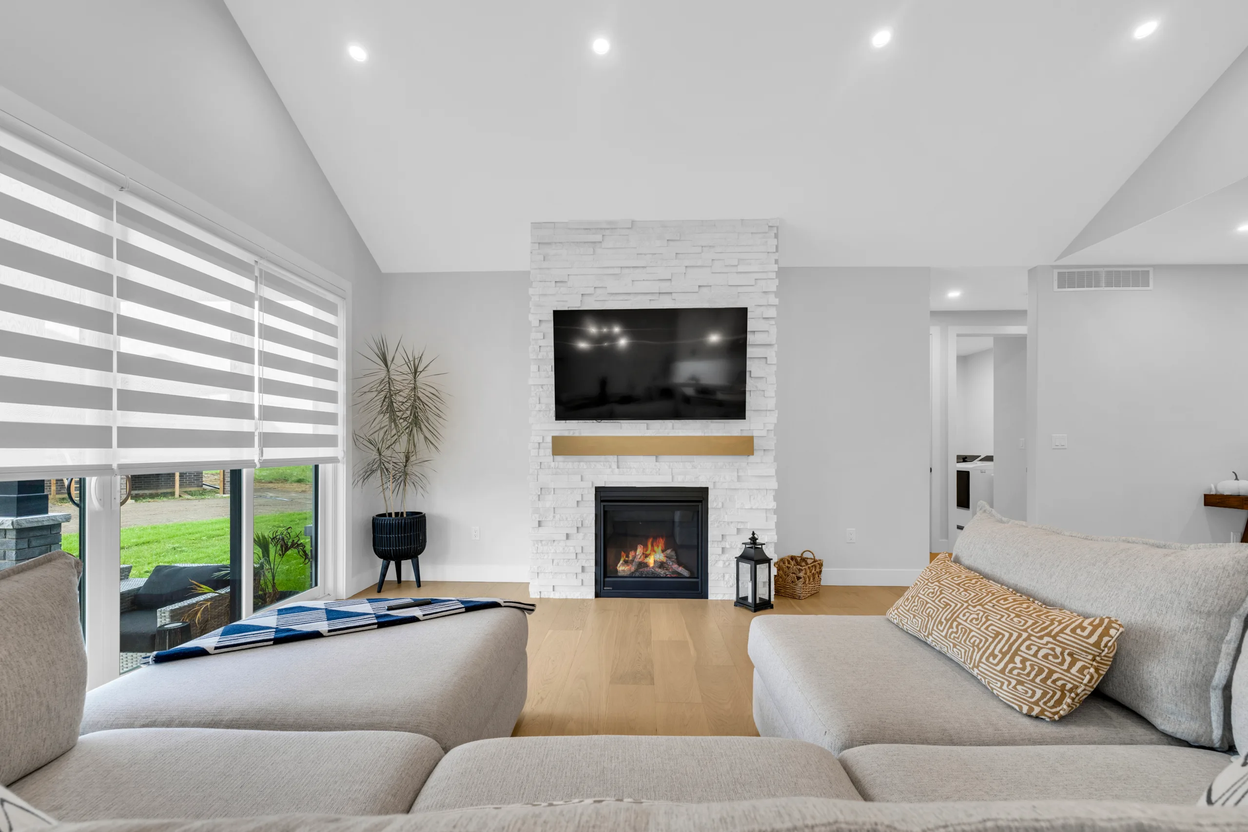 Living room with vaulted ceiling and floor to ceiling stone fireplace